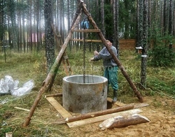 Установка бетонного кольца в колодец на треноге